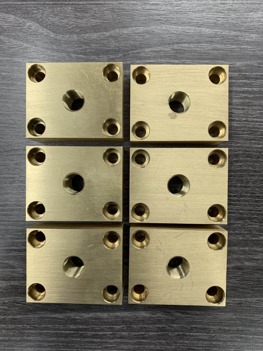 A completed repeat-production batch of identical machined brass components