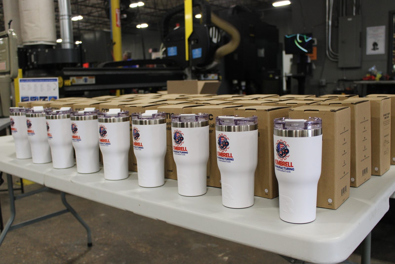 A table of white Kimbrell Manufacturing tumblers and boxes
