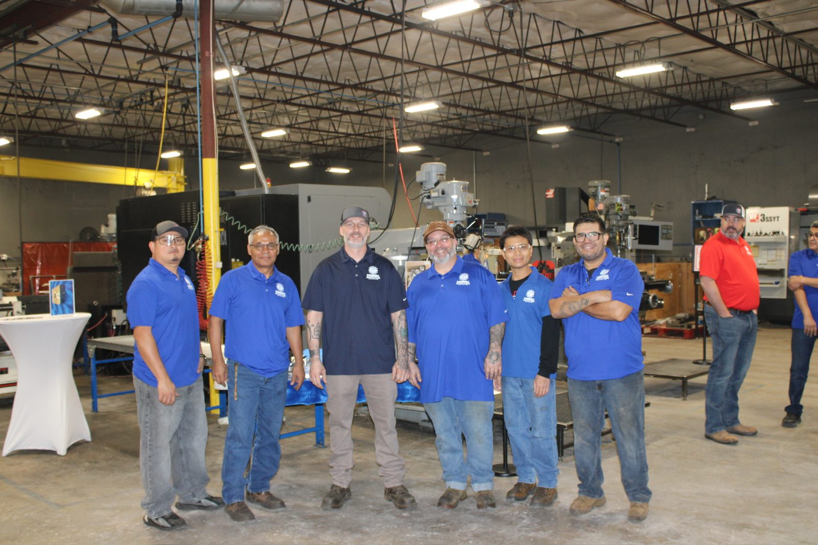 Six Kimbrell shop team members in company polos on the shop floor