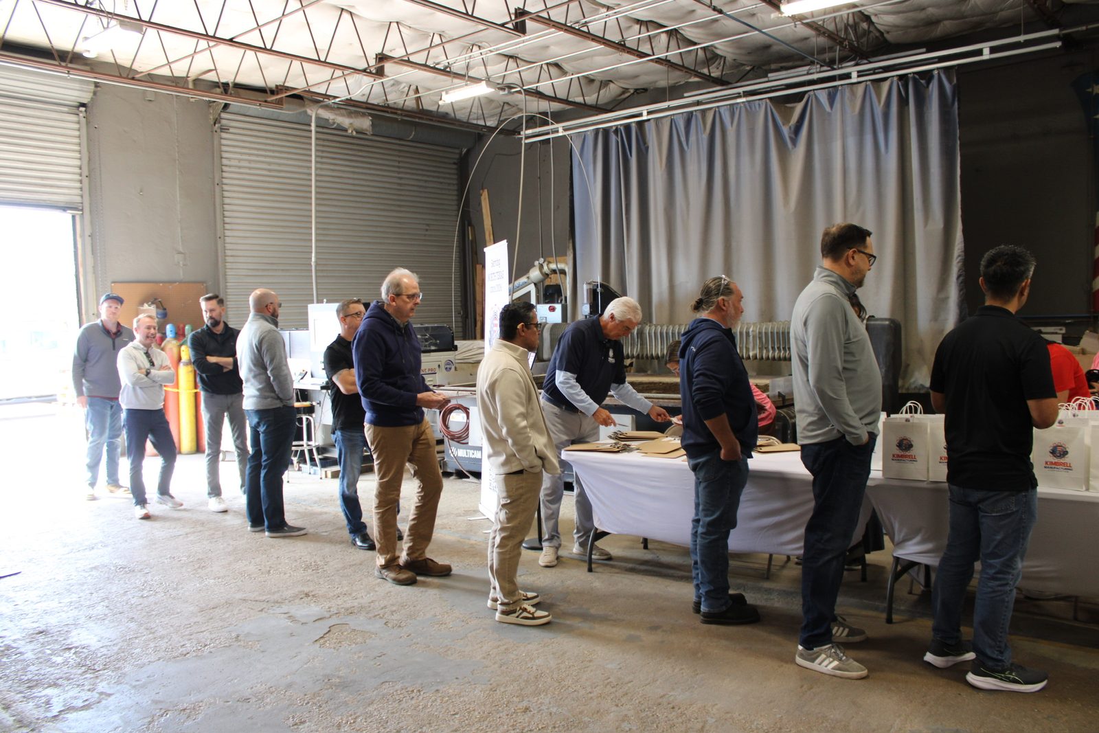Guests looking over machined parts on a display table