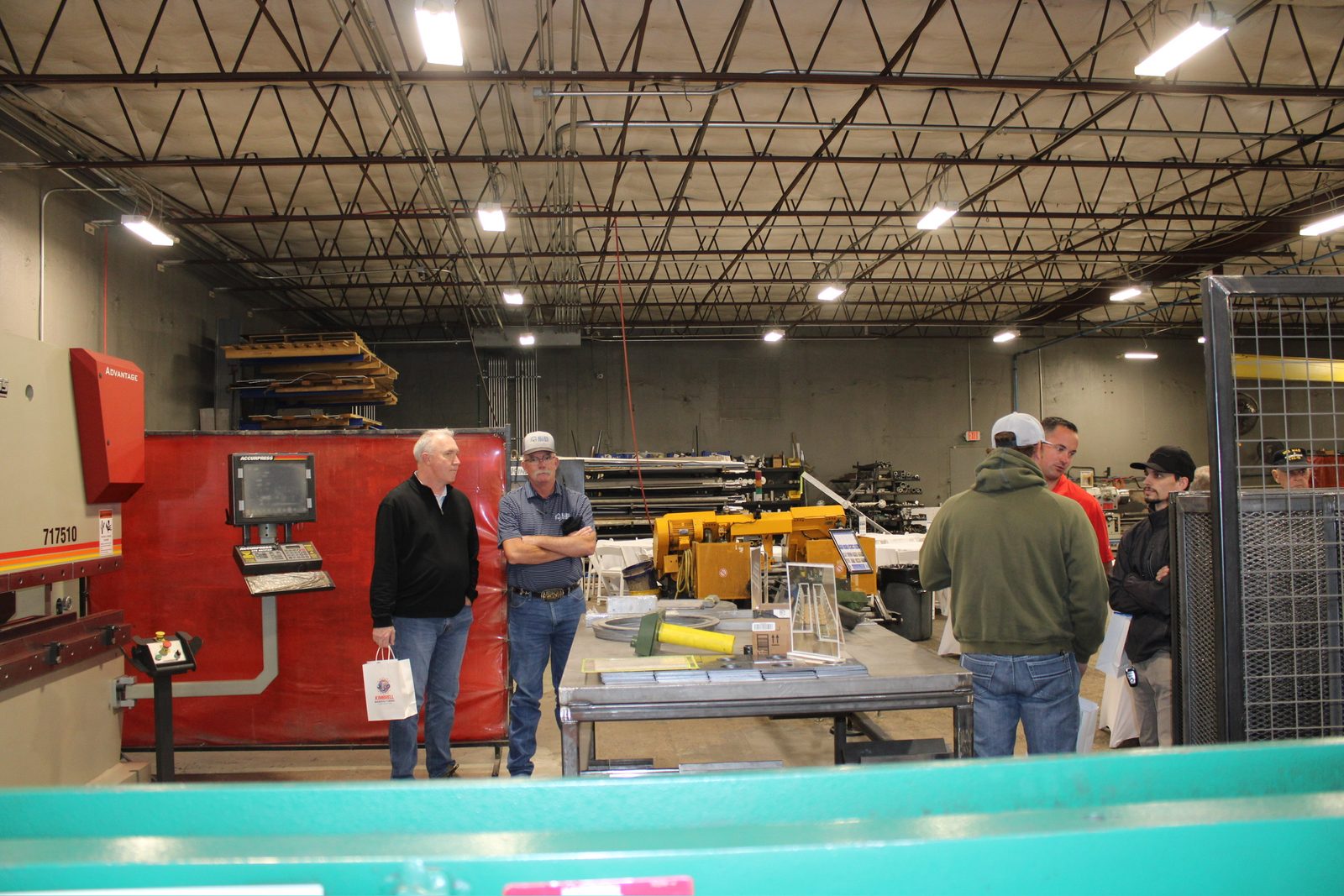 Guests touring the fabrication area near the press brake