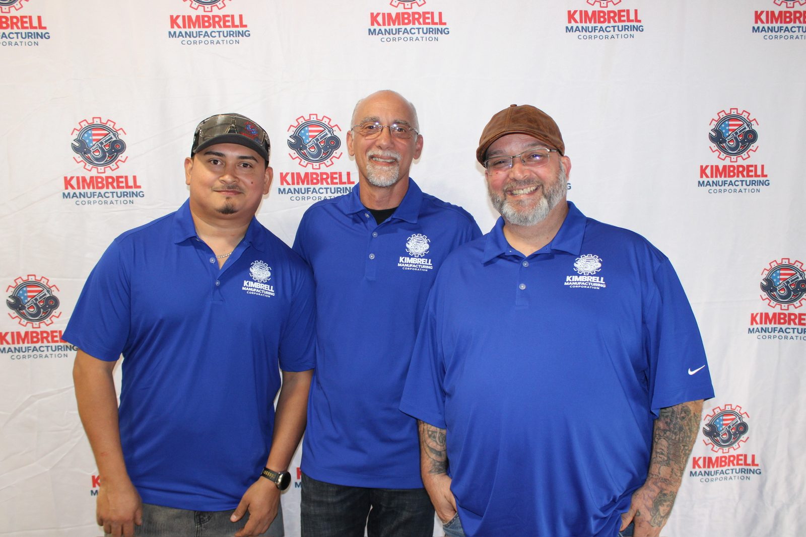 Three Kimbrell team members at the company photo wall