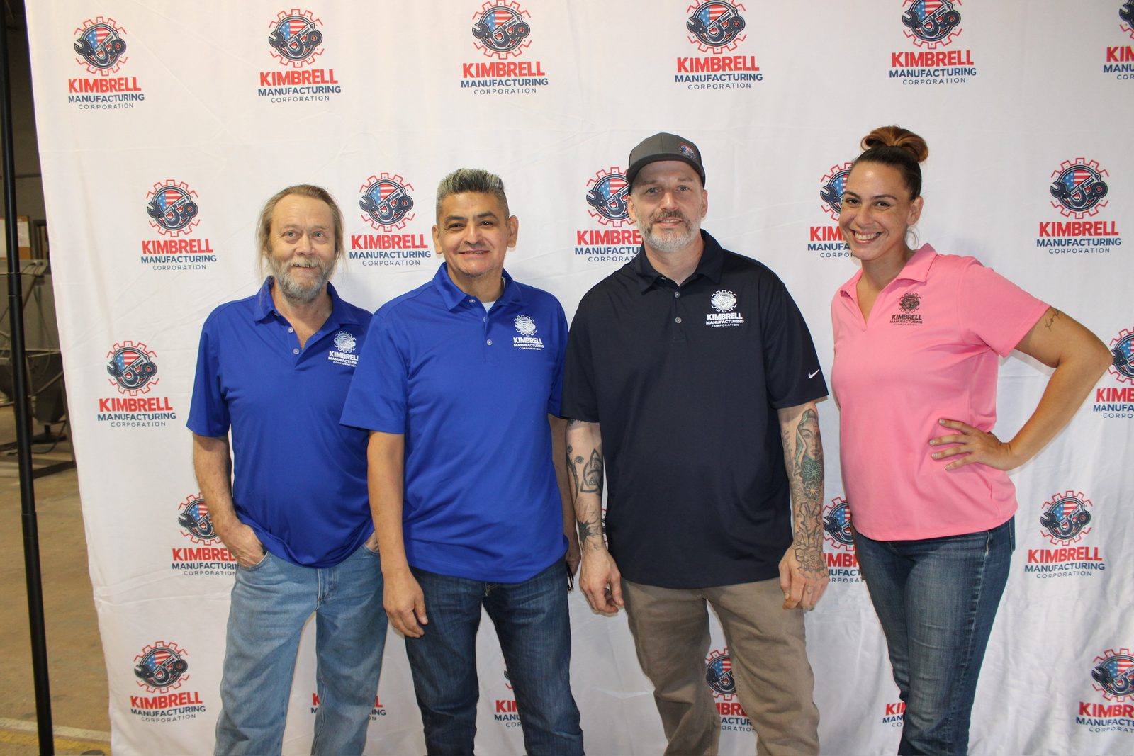 Four Kimbrell team members at the company photo wall
