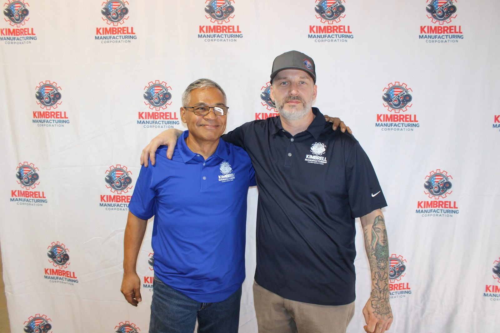 Two Kimbrell team members with arms around each other at the photo wall