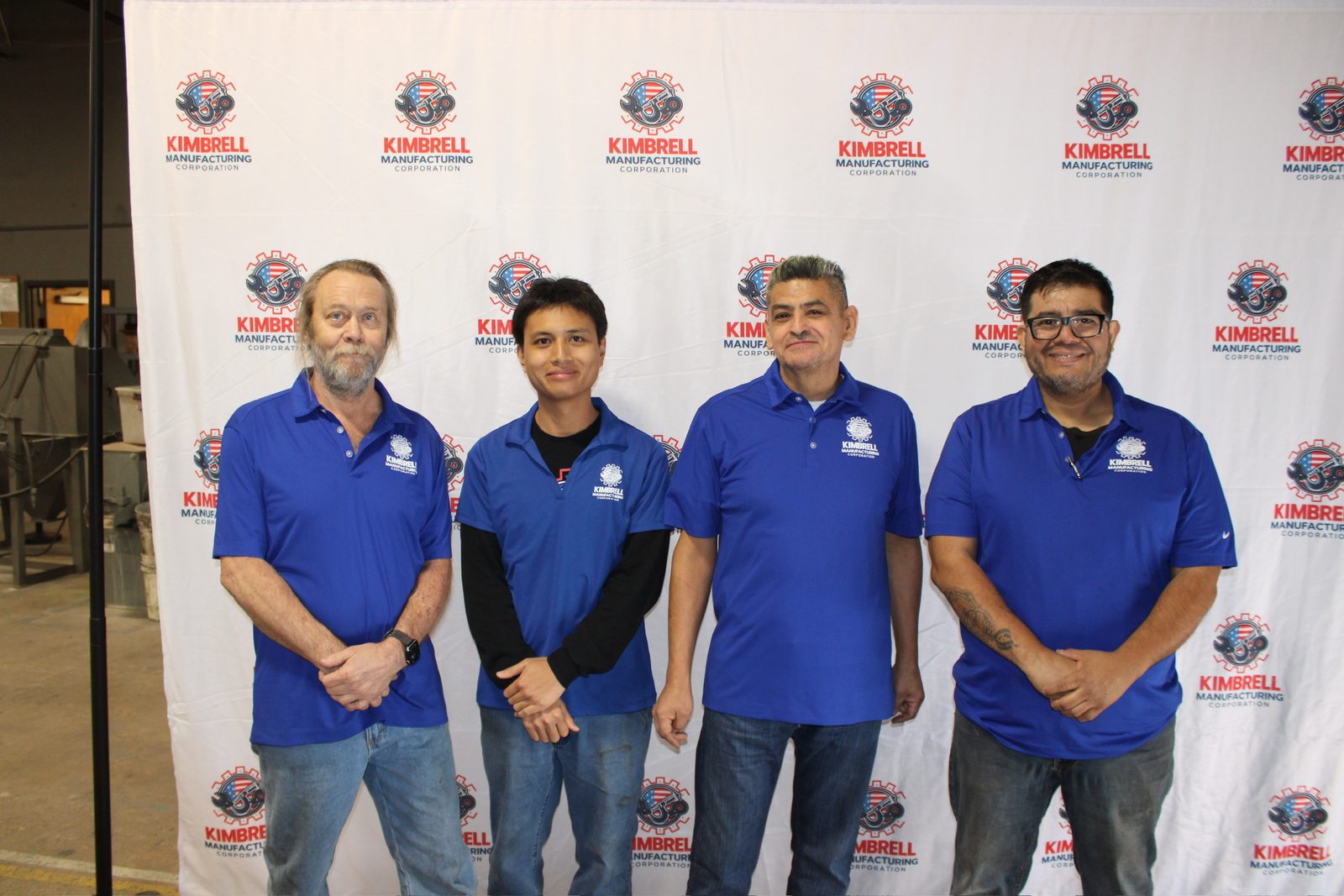 Four Kimbrell shop team members at the company photo wall