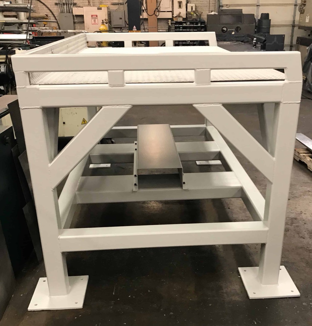 Fabricated staging table with checker-plate top and rail