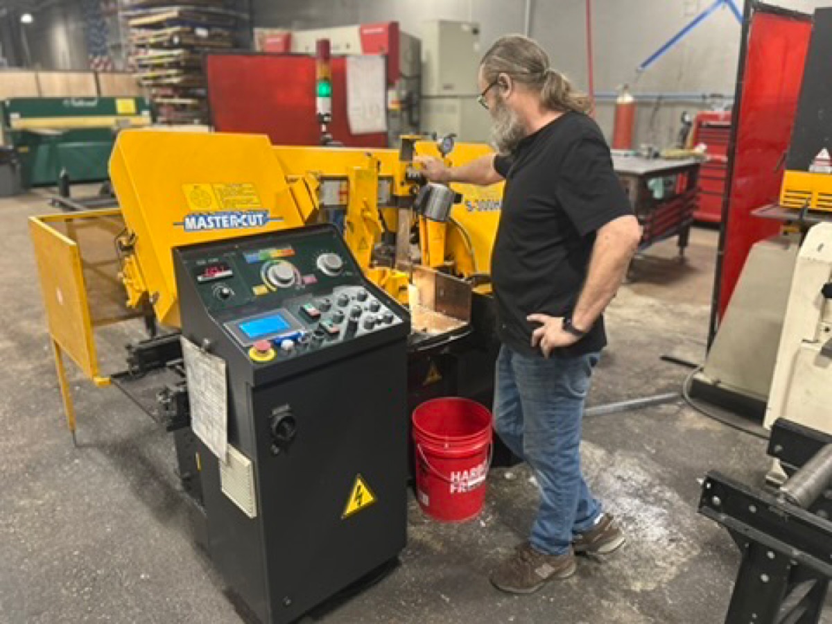 Operator setting up a cut on the CNC saw at Kimbrell Manufacturing Corporation