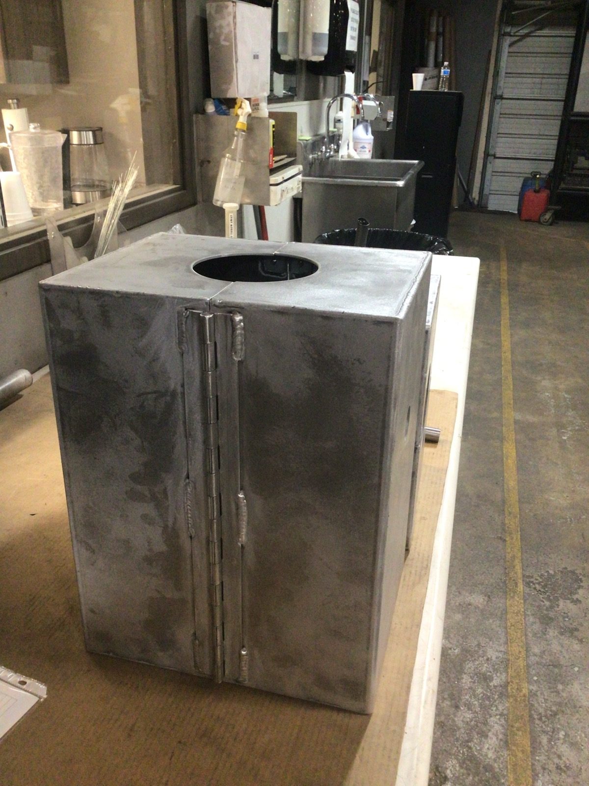 Custom fabricated steel covering with a welded hinged access door, built by Kimbrell Manufacturing Corporation