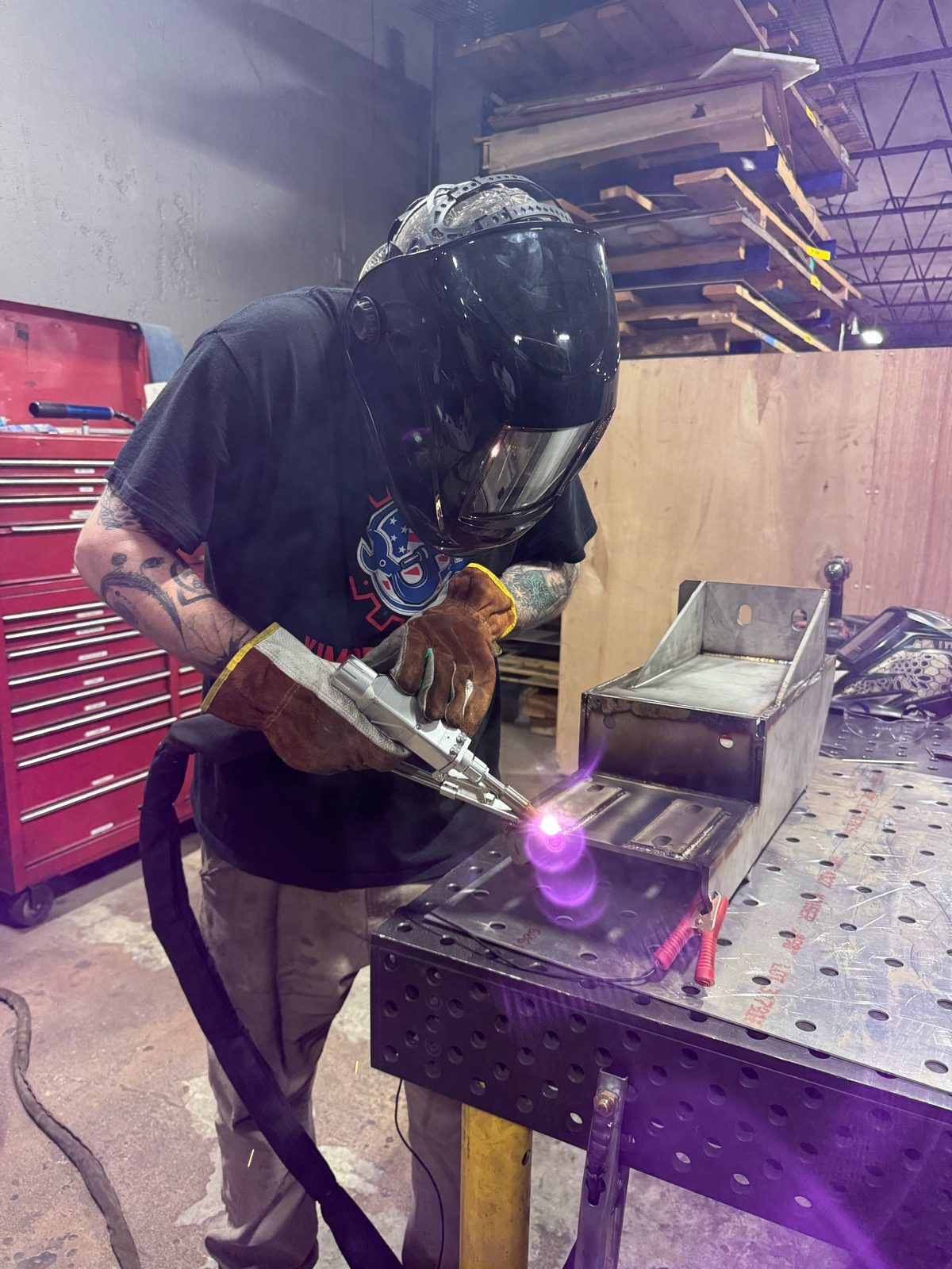 Fabricator welding a sheet-metal assembly on the shop floor